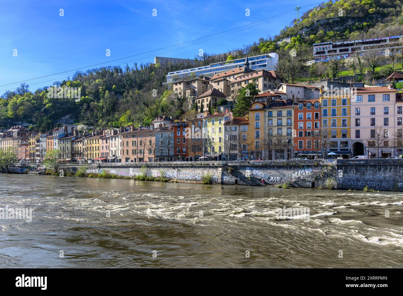 Wunderschöne, farbenfrohe Häuser und Geschäfte am Fluss entlang der Nordseite des Isère in Grenoble, Südostfrankreich. Stockfoto