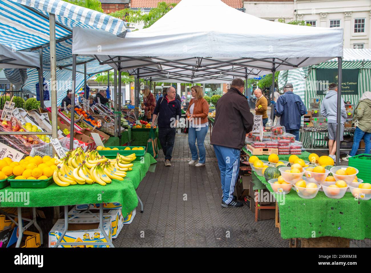 Leute, die frisches Obst und Gemüse zum Verkauf an einem Marktstand in der Marktstadt Louth England kaufen Stockfoto