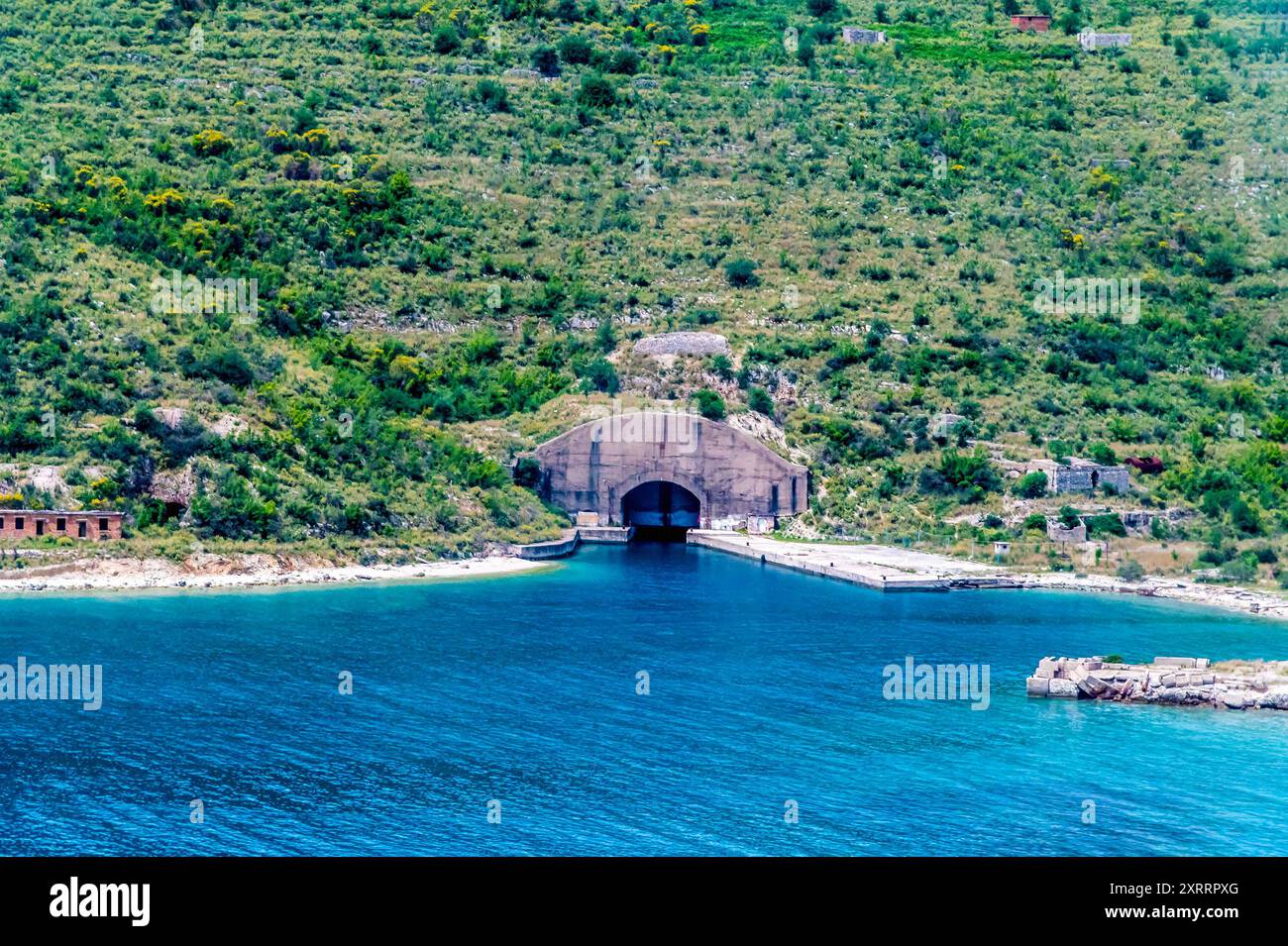 Blick auf einen stillgelegten U-Boot-Bunker vom Strand Palermo auf der Straße nach Sarandra, Albanien im Sommer Stockfoto