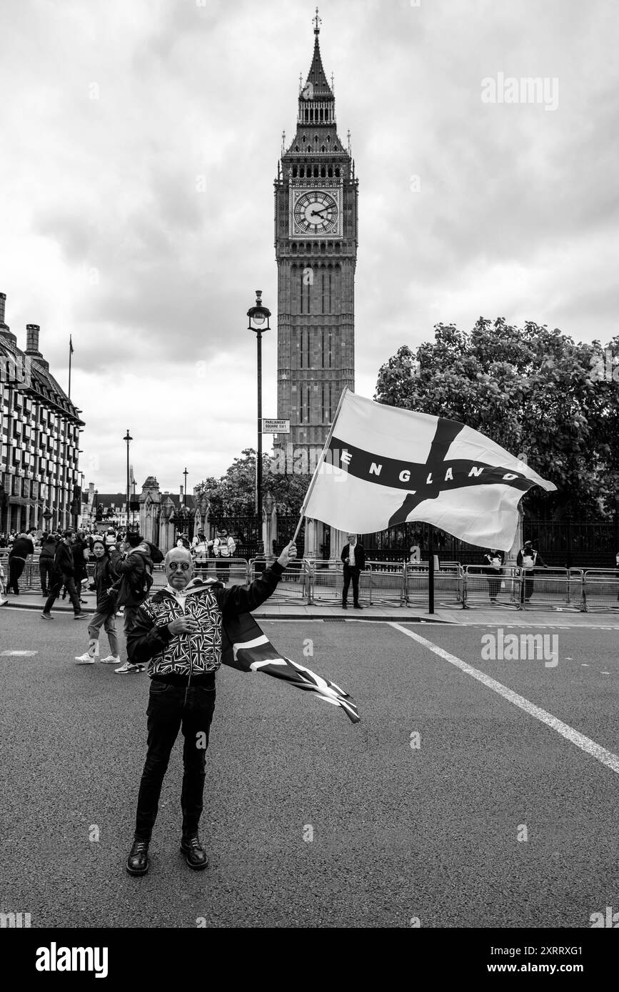 Ein Mann, der ein Union Jack Kostüm trägt, schwingt vor Big Ben ein englisches Kreuz der St. George Flagge nach einer Kundgebung gegen Two Tier Poliing, London, Großbritannien. Stockfoto