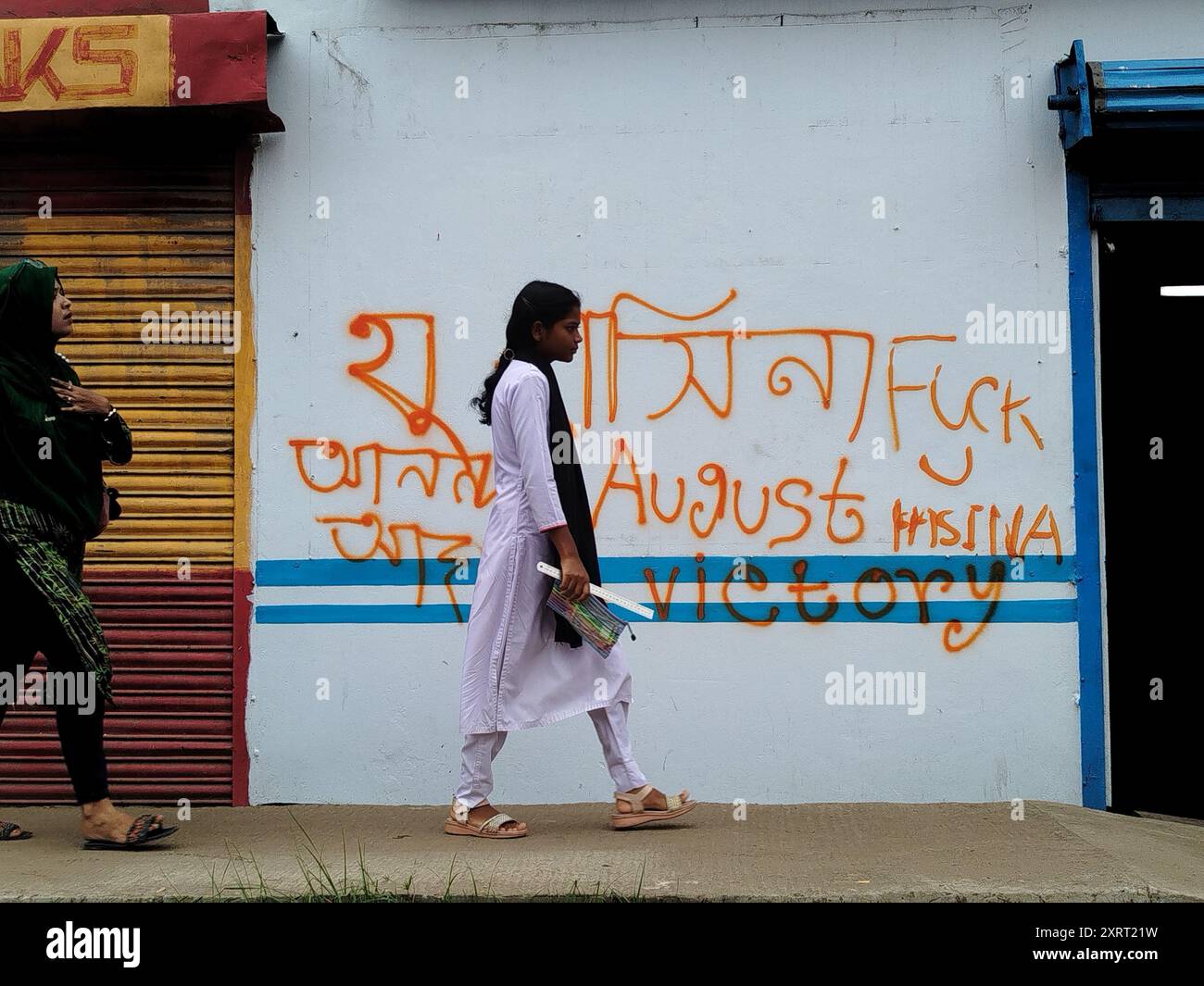 Joyput Hat, Bangladesch. August 2024. Die Studenten passieren als Slogan, der auf einer Wand geschrieben steht, mit dem Aufschrift „August Victoria“ in der Nähe einer Straße des Joypurhat-Bezirks. (Kreditbild: © MD Mehedi Hasan/ZUMA Press Wire) NUR REDAKTIONELLE VERWENDUNG! Nicht für kommerzielle ZWECKE! Stockfoto