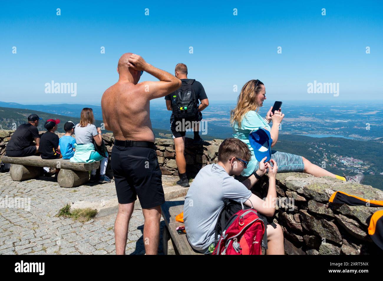 Aktive Menschen Alter Mann, eine Frau mittleren Alters mit einem Handy, und ein Junge, der an einem sonnigen Sommertag auf der Landschaft von Snezka Polen ruht Stockfoto