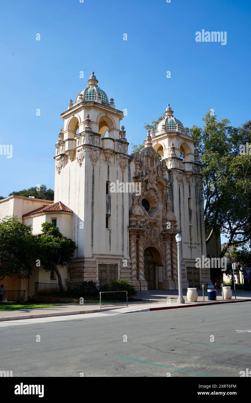 Ein historisches Theatergebäude mit komplexen architektonischen Details und zwei Türmen mit bunten Kuppeln, vor einem klaren blauen Himmel, Representin Stockfoto