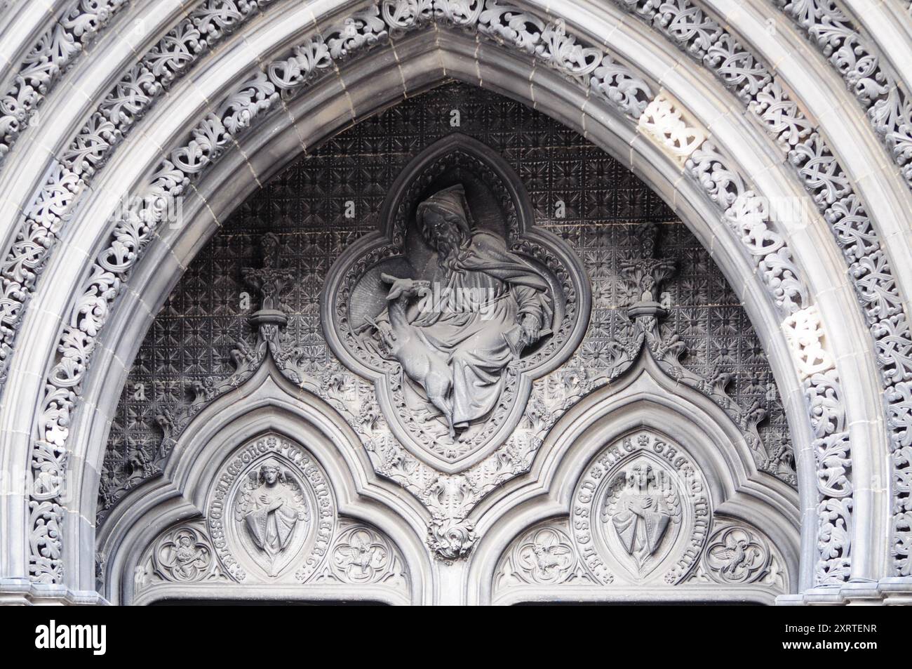 Kunstvoller Steinbogen mit mittelalterlichen religiösen Figuren und gotischer Architektur Stockfoto