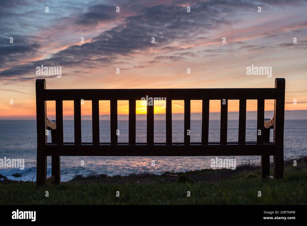 Alte Holzbank mit Blick auf das Meer bei Sonnenuntergang. Stockfoto