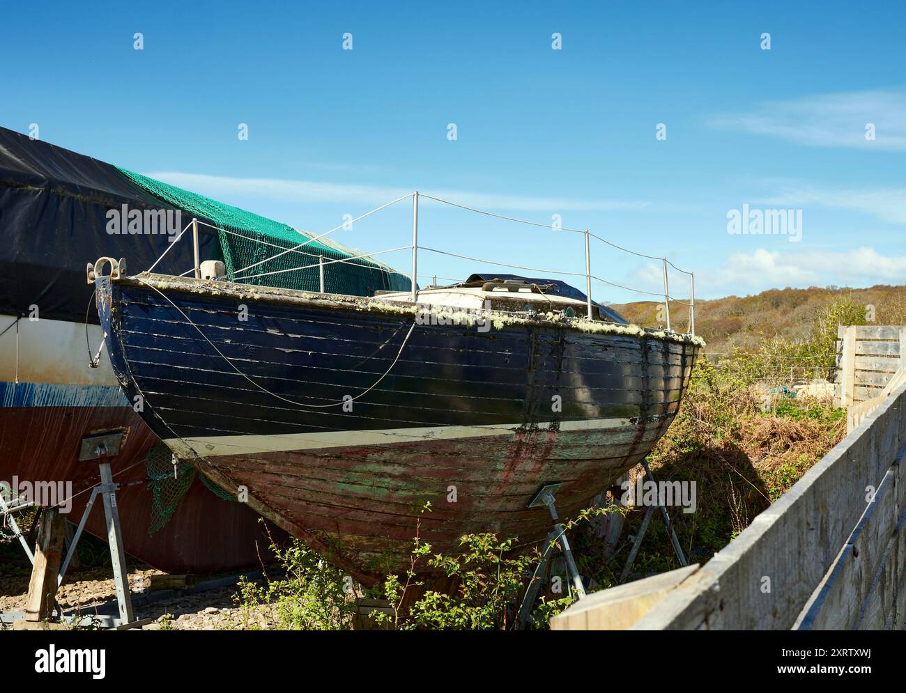 Der Rumpf eines Segelbootes wartet auf die Aufmerksamkeit des Bootsbauers im Yachthafen und Yachthafen in Arisaig, Lochaber Stockfoto