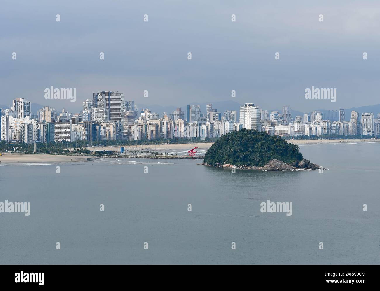 Landschaft der Stadt Santos mit Blick auf die Insel Urubuquecaba, die Mole, den Strand und die Stadt im Hintergrund. Küste des Inneren von Sao Paul Stockfoto