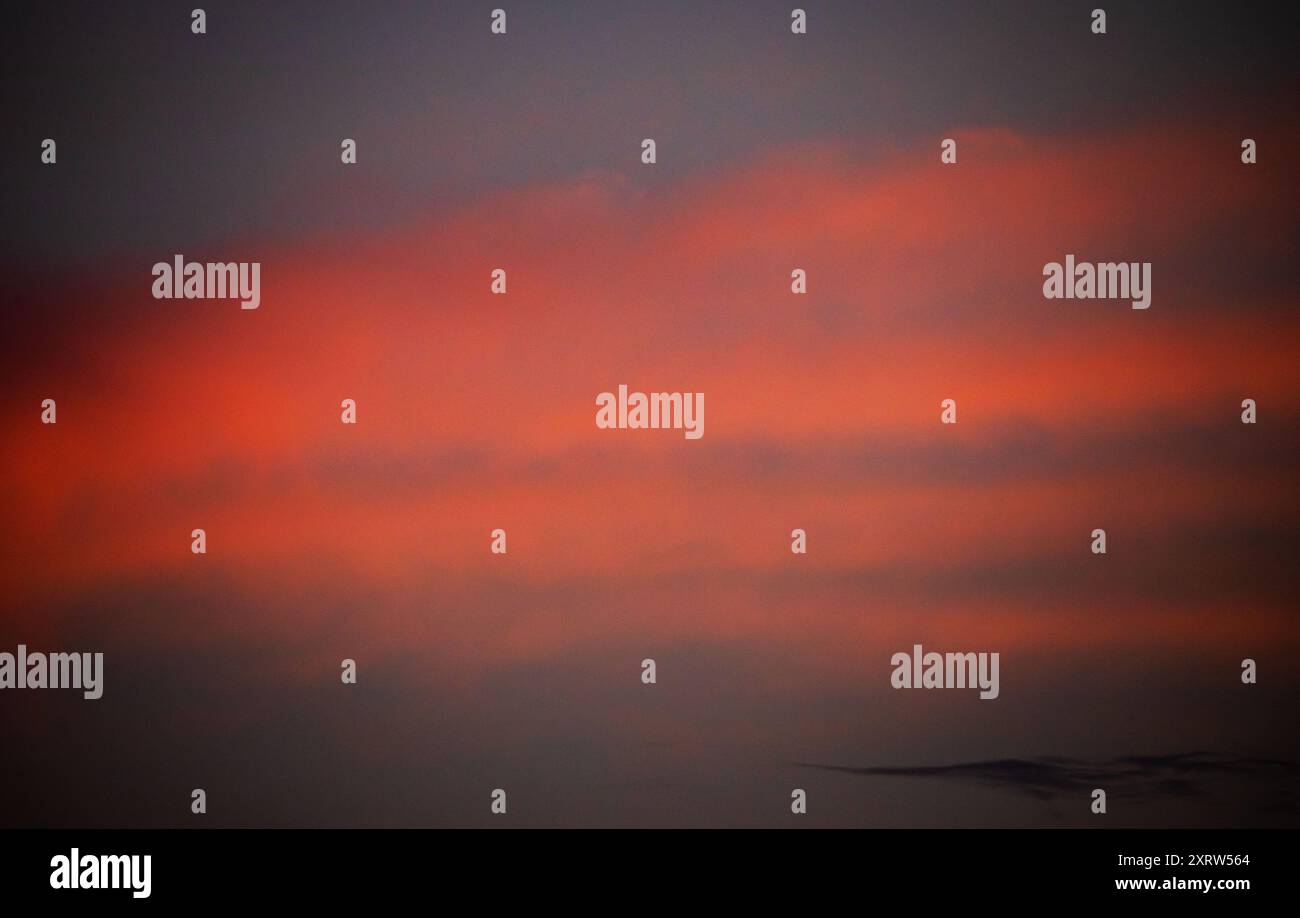 Die untergehende Sonne schafft ein abstraktes Pastellbild von Himmel und Wolken. Stockfoto