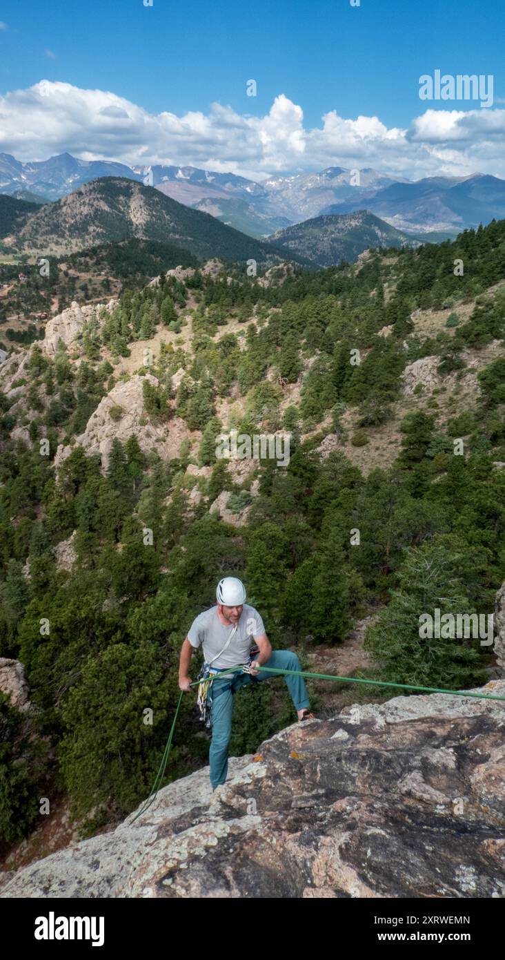 Männlicher Einzelerwachsener Abseiler vom Gipfel des Daumenbuttes. Estes Park, Colorado, Stockfoto