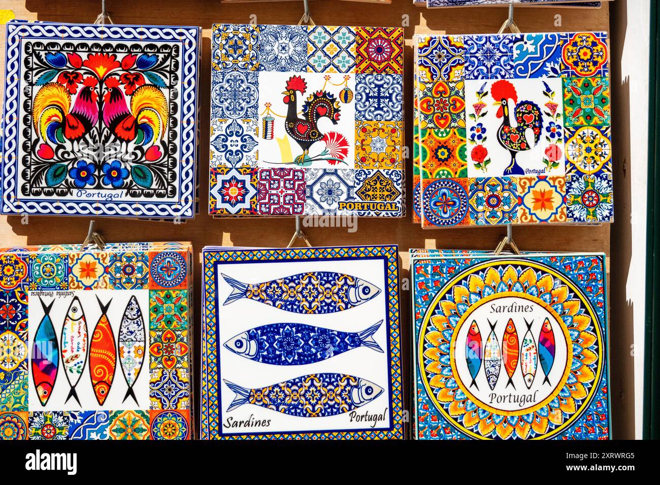 Portugiesisches Souvenir Dekorative bemalte Keramikfliesen mit Sardinen und dem Hahn von Barcelos beliebte Geschenke aus Portugal Stockfoto