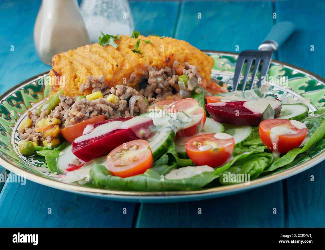 Cottage Pie mit Süßkartoffelbrei und Salat garniert mit Dressing. Stockfoto