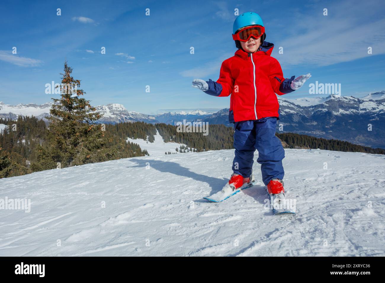 Junger Skifahrer in knalliger Ausrüstung auf einem wunderschönen, verschneiten Berg Stockfoto