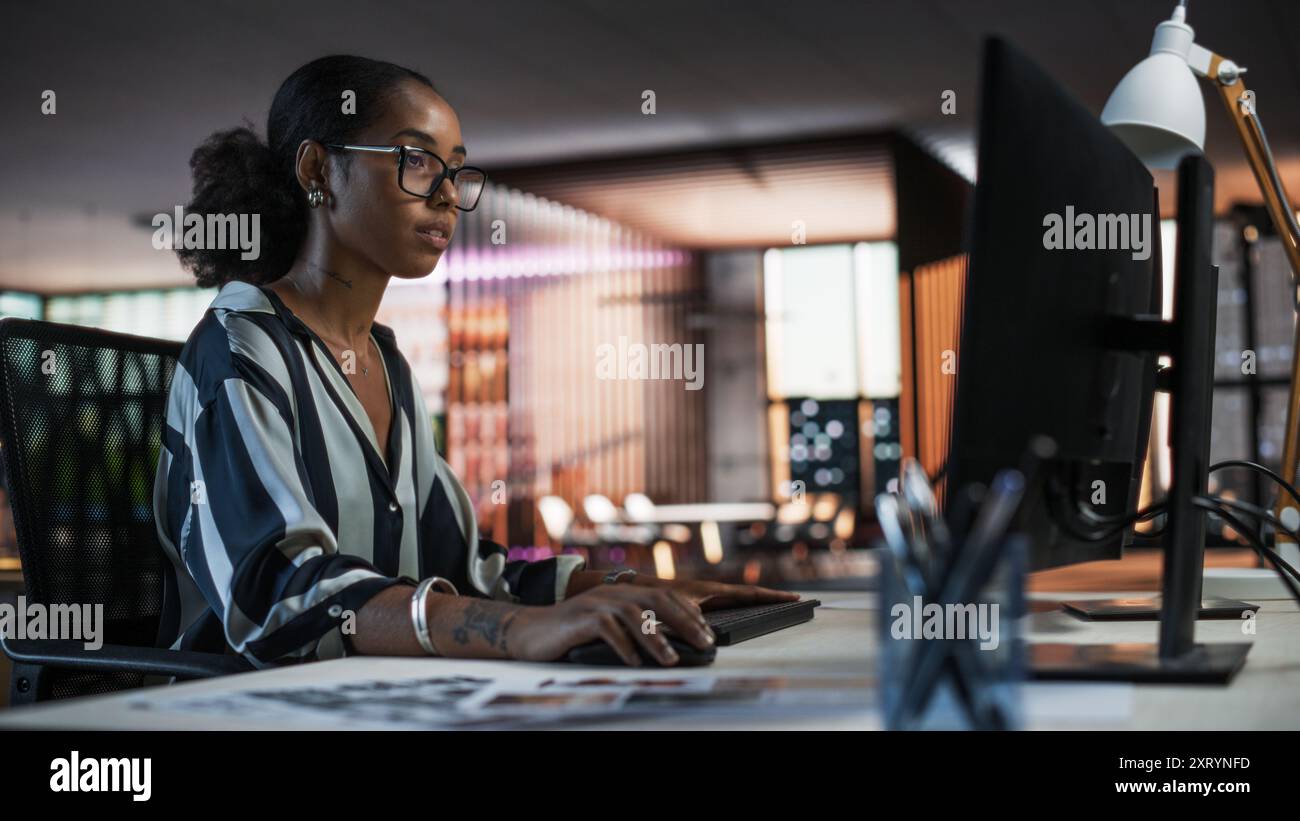 Porträt einer schönen schwarzen Frau, die einen Desktop-Computer verwendet, Daten analysiert, denkt und Probleme löst. Weibliche Projektmanagerin, die in der Kreativagentur arbeitet und die Marketingstrategie für soziale Medien überprüft Stockfoto