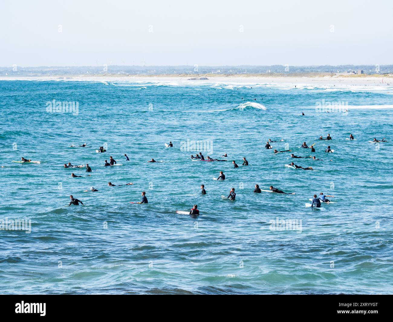 Strand La Torche, Frankreich; 9. August 2024: Surfer warten auf Wellen im Wasser am Strand La Torche, Französisch-Bretagne Stockfoto