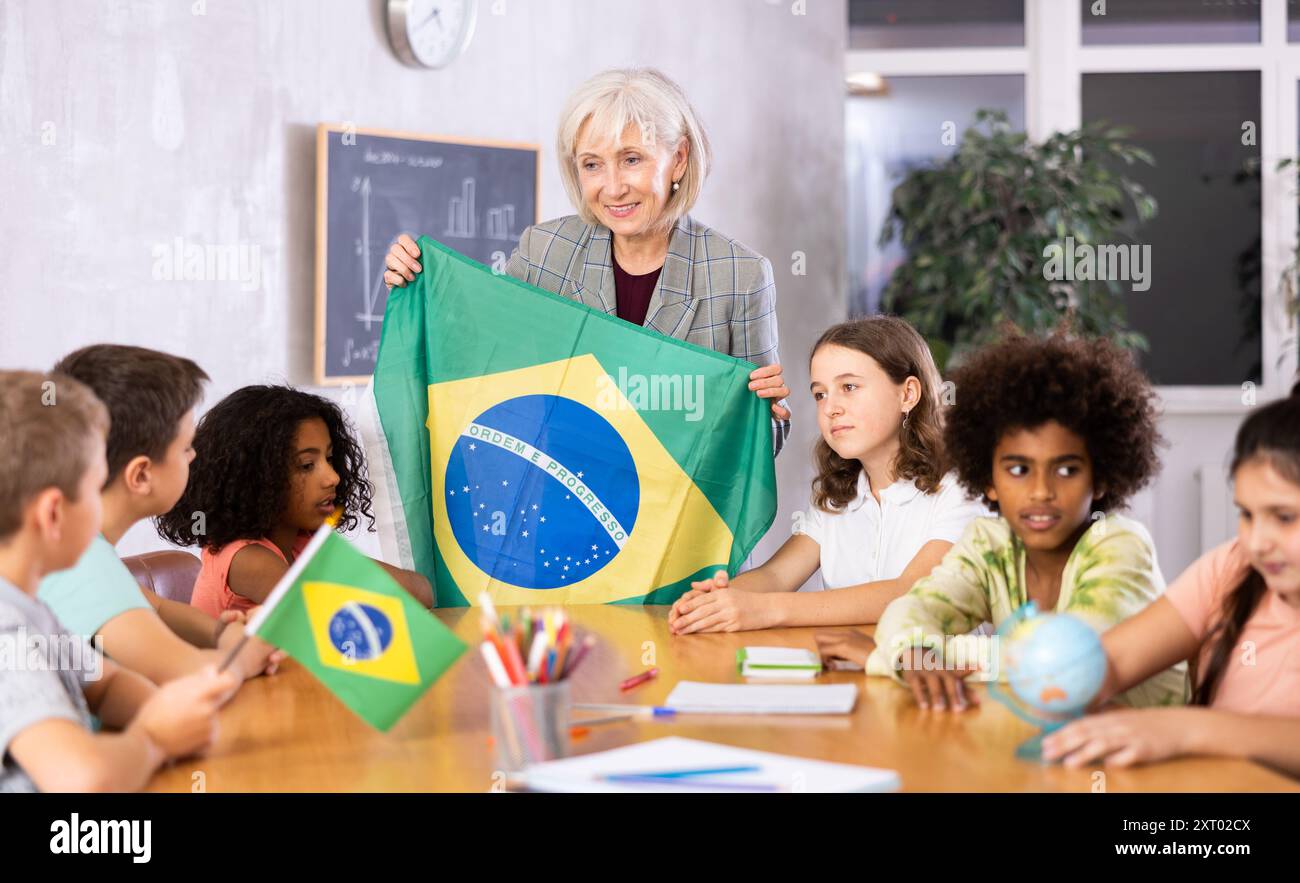 Eine reife Lehrerin erzählt den Schülern die Geschichte Brasiliens Stockfoto