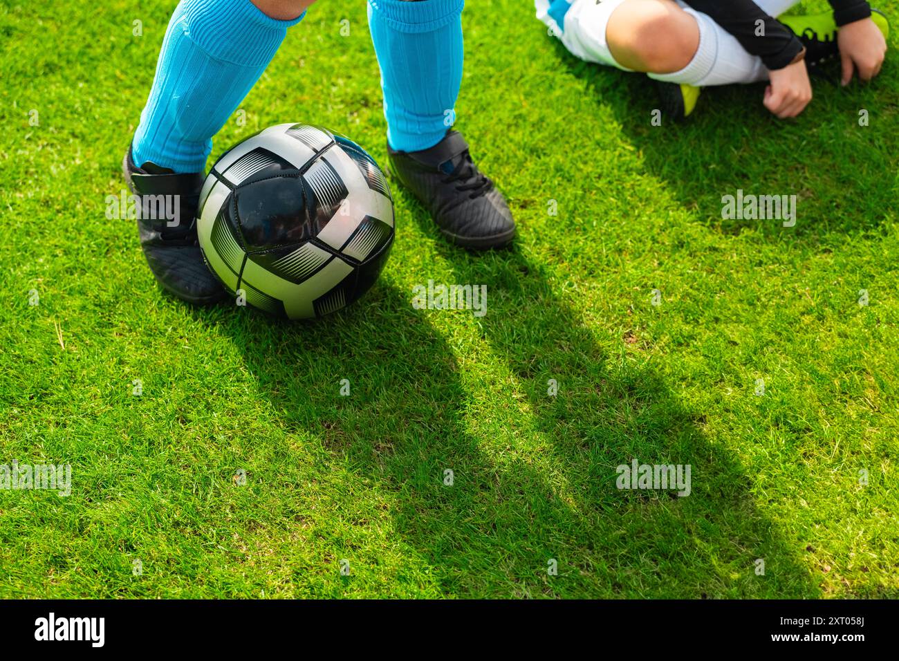 Black Football, gespielt von einem Fußballspieler in der Nähe der Füße des Spielers Stockfoto