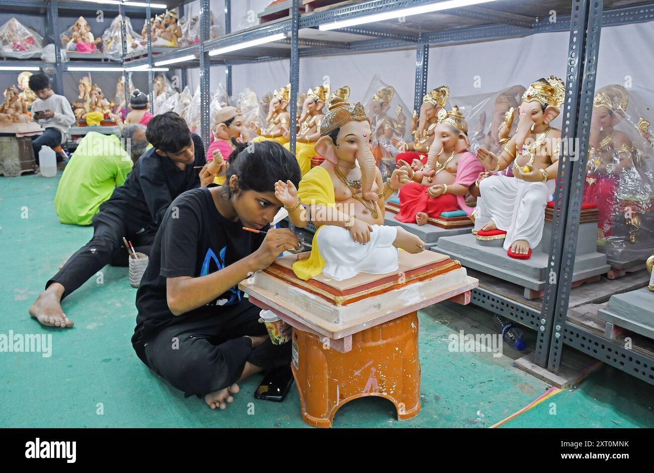 Mumbai, Indien. August 2024. Eine Frau malt ein Idol des Elefantenköpfigen hinduistischen Gottes Ganesh in einem Workshop vor dem bevorstehenden Ganesh Chaturthi Festival in Mumbai. Quelle: SOPA Images Limited/Alamy Live News Stockfoto