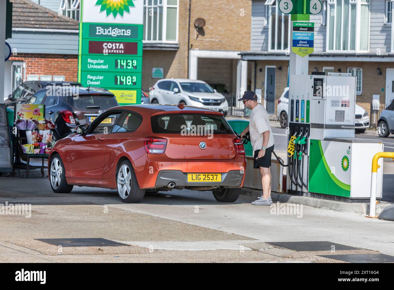 Ein Mann, der sein Auto in einer Tankstelle betankt. Stockfoto