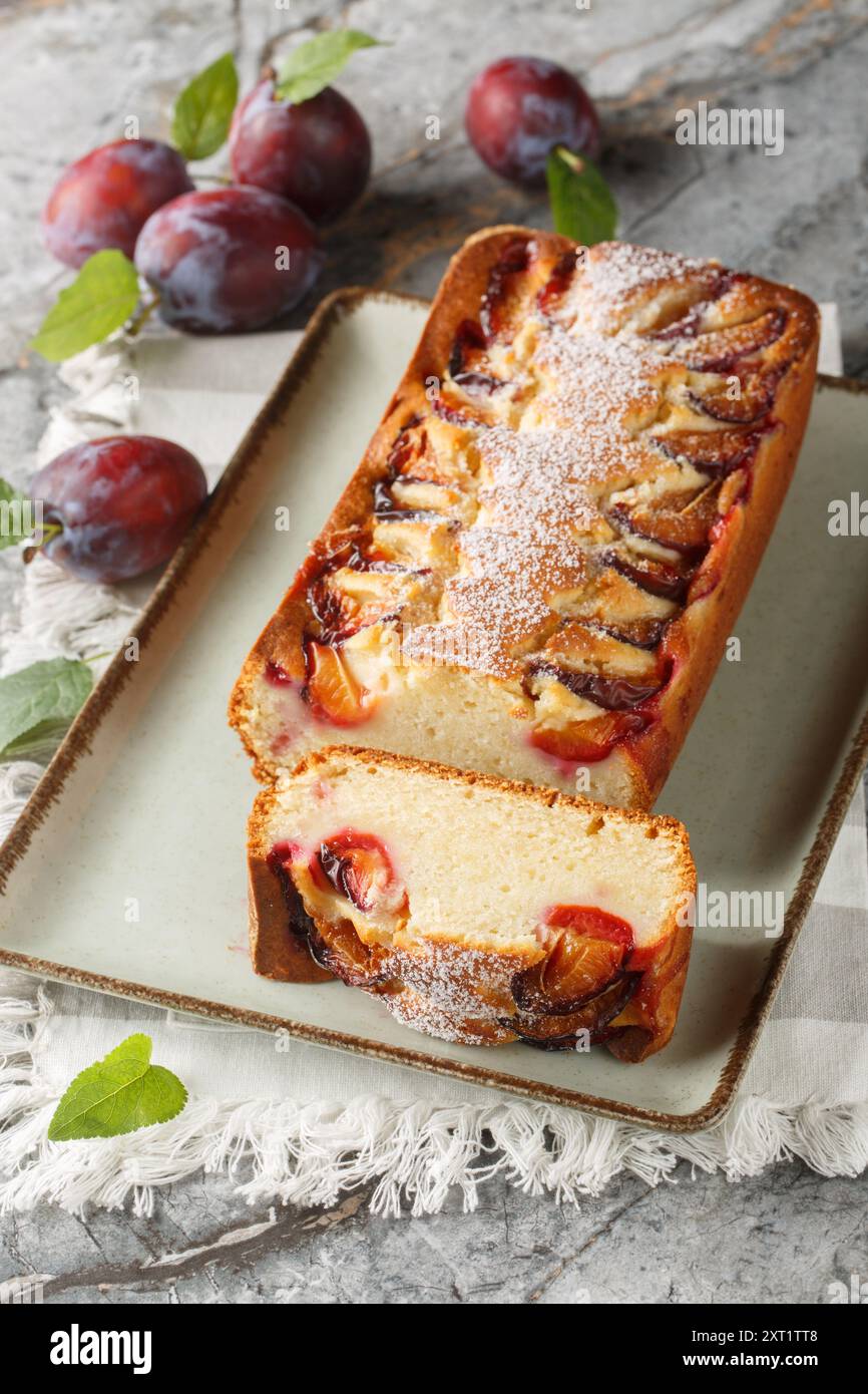 Italienischer Joghurt Pflaumenkuchen Torta di Susine Nahaufnahme auf dem Teller auf dem Tisch. Vertikal Stockfoto