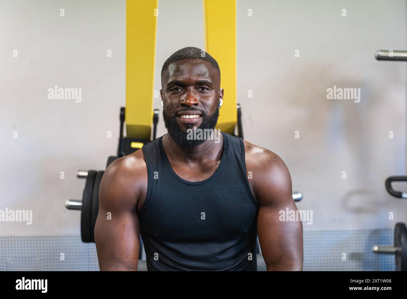 Schwarzer Personal Trainer lächelt während des Workouts im Fitnessstudio Stockfoto