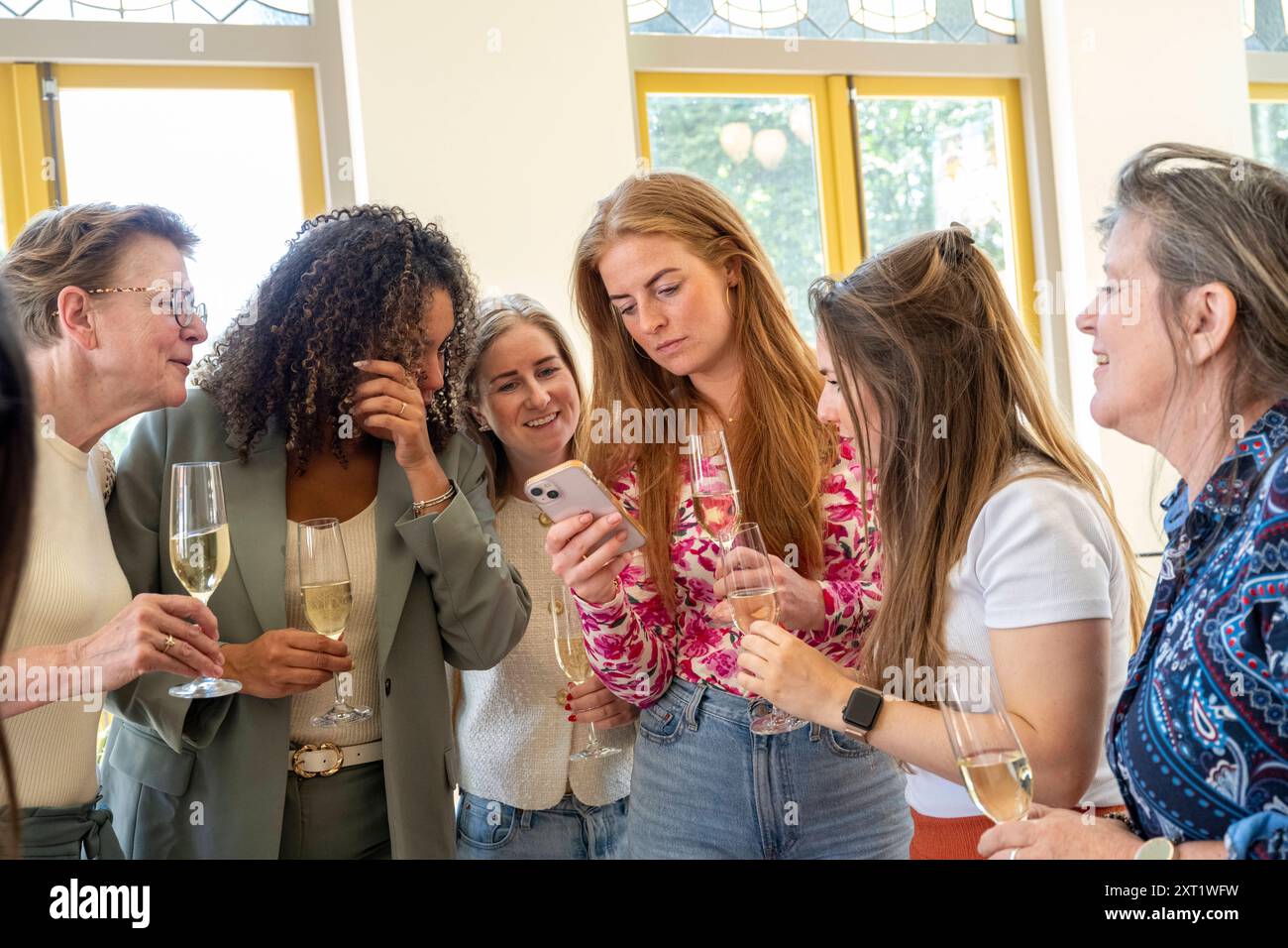 Eine Gruppe von Frauen, die einen Moment über ein Smartphone bei einem geselligen Treffen mit Getränken verbringen. Panc05674 Copyright: XConnectxImagesx Stockfoto