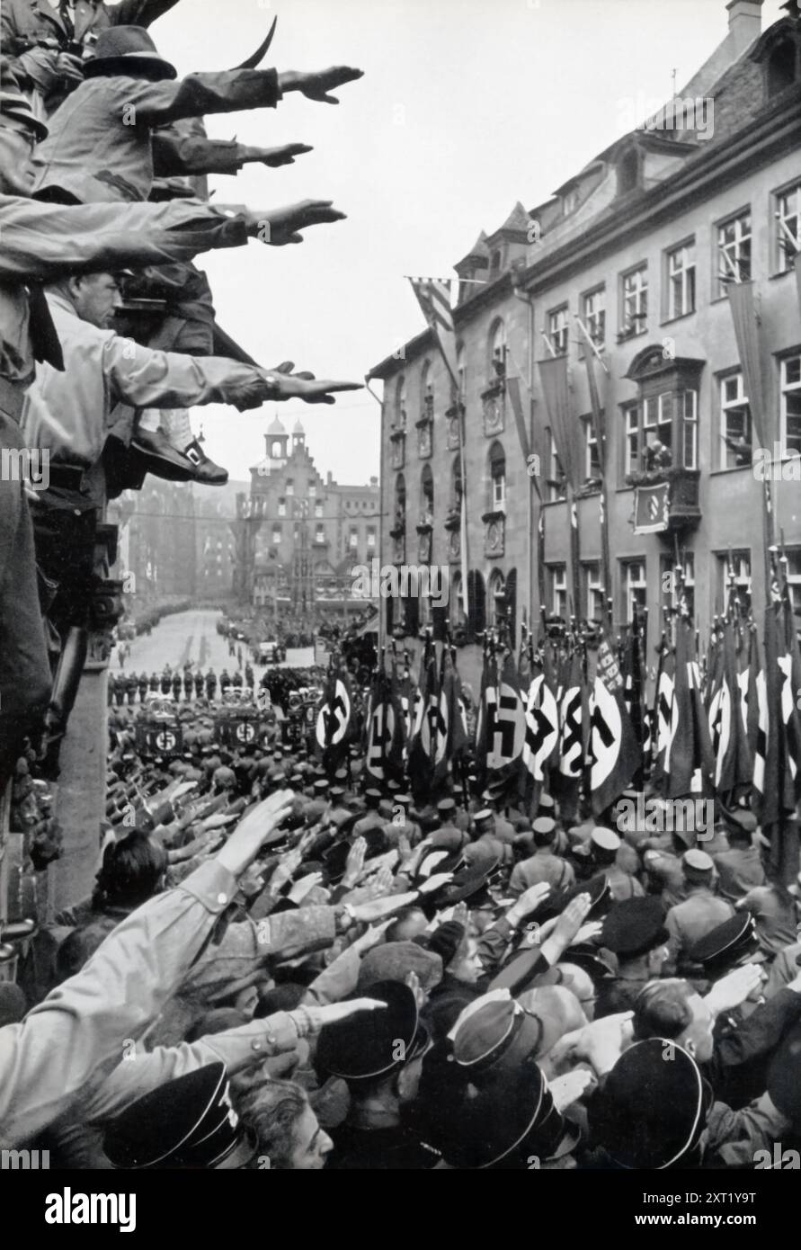 Das Foto zeigt die Kundgebung der Nazi-Partei 1933, bekannt als „Sieg des Glaubens“. Braune Kolumnen der SA (Sturmabteilung), die eine Schlüsselrolle bei Hitlers Aufstieg an der Macht spielten, werden gesehen, wie sie an Hitler vorbeimarschierten, um Loyalität und Triumph zu zeigen. Diese Kundgebung war eine der ersten Großveranstaltungen der Nazis, nachdem sie die Kontrolle über Deutschland übernommen hatten, und symbolisierte die Festigung ihrer Macht und den Beginn ihres totalitären Regimes. Stockfoto