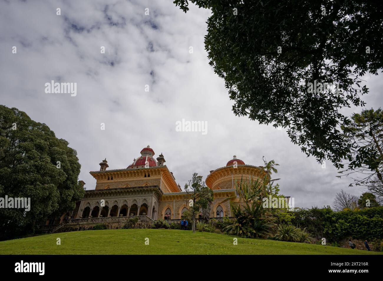 Außenansicht des Monserrate Palace in Sintra, eingerahmt von Bäumen und bewölktem Himmel Stockfoto