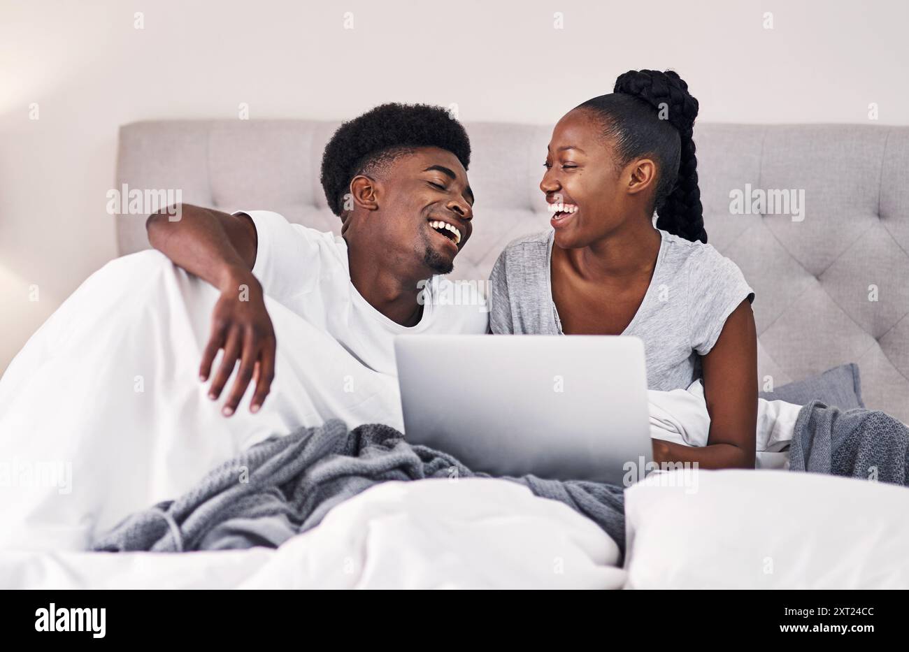 Schwarzes Paar, entspannen und lachen Sie mit Laptop-Comedy-Film, Social-Media-Memes oder Unterhaltung. Mann, Frau und zusammen zu Hause mit Technik Stockfoto