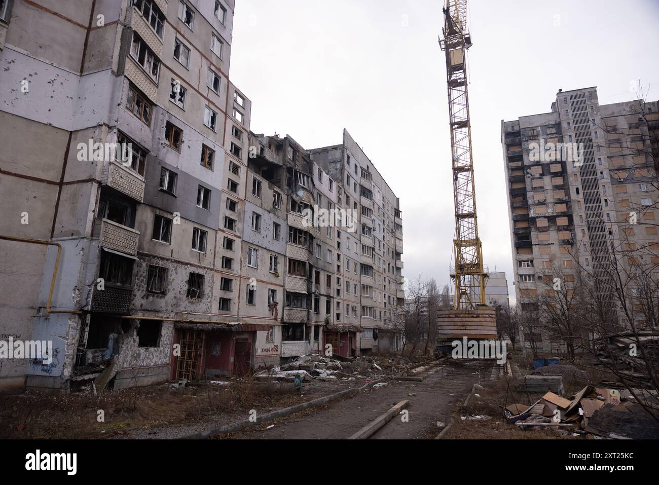 Schäden an ziviler Infrastruktur in Saltivka, Region Charkow: Während der ersten Wochen der Invasion von 2022 positionierten sich russische Truppen auf der Ringstraße und feuerten direkt auf die Wohnanlagen am Stadtrand von Charkow ab. Jetzt, mehr als zwei Jahre nach dem ersten Kampf, arbeitet die Stadt daran, die stark beschädigten Gebäude, in denen viele noch leben, wieder aufzubauen und abzureißen. Stockfoto