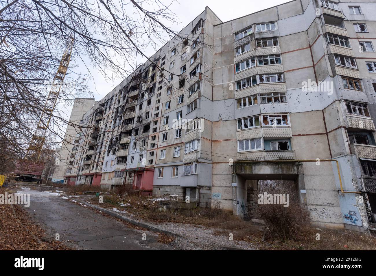 Schäden an ziviler Infrastruktur in Saltivka, Region Charkow: Während der ersten Wochen der Invasion von 2022 positionierten sich russische Truppen auf der Ringstraße und feuerten direkt auf die Wohnanlagen am Stadtrand von Charkow ab. Jetzt, mehr als zwei Jahre nach dem ersten Kampf, arbeitet die Stadt daran, die stark beschädigten Gebäude, in denen viele noch leben, wieder aufzubauen und abzureißen. Stockfoto