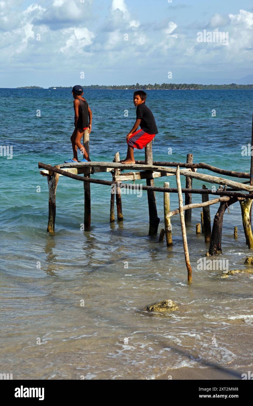 Kuna-Jungs auf rustikalem Steg aus Holzstangen, Stäben und Balken, Carti Sugtup Island, San Blas Inseln, Panama Stockfoto