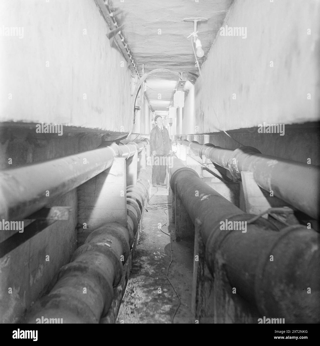 Aktuell 11-1951: Wandern unter den Straßen. In Oslos Abwassersystem. Unter dem Zentrum verläuft auch ein Gemeindetunnel, in dem sich die Leitungen für Gas-, Wasser- und Stromkabel befinden. Solche Kabel sind überall sonst im Boden vergraben, so dass der Tunnel zu Fuß begehbar ist und Sie keine Löcher in der Straße graben müssen, wenn Sie Reparaturen durchführen müssen. Dieser Tunnel ist 1.800 Meter lang und alle drei Wochen werden alle Kabel sorgfältig überprüft. Foto: Arne Kjus / aktuell / NTB ***Foto ist nicht bildverarbeitet*** dieser Bildtext wird automatisch übersetzt dieser Bildtext wird automatisch übersetzt Stockfoto