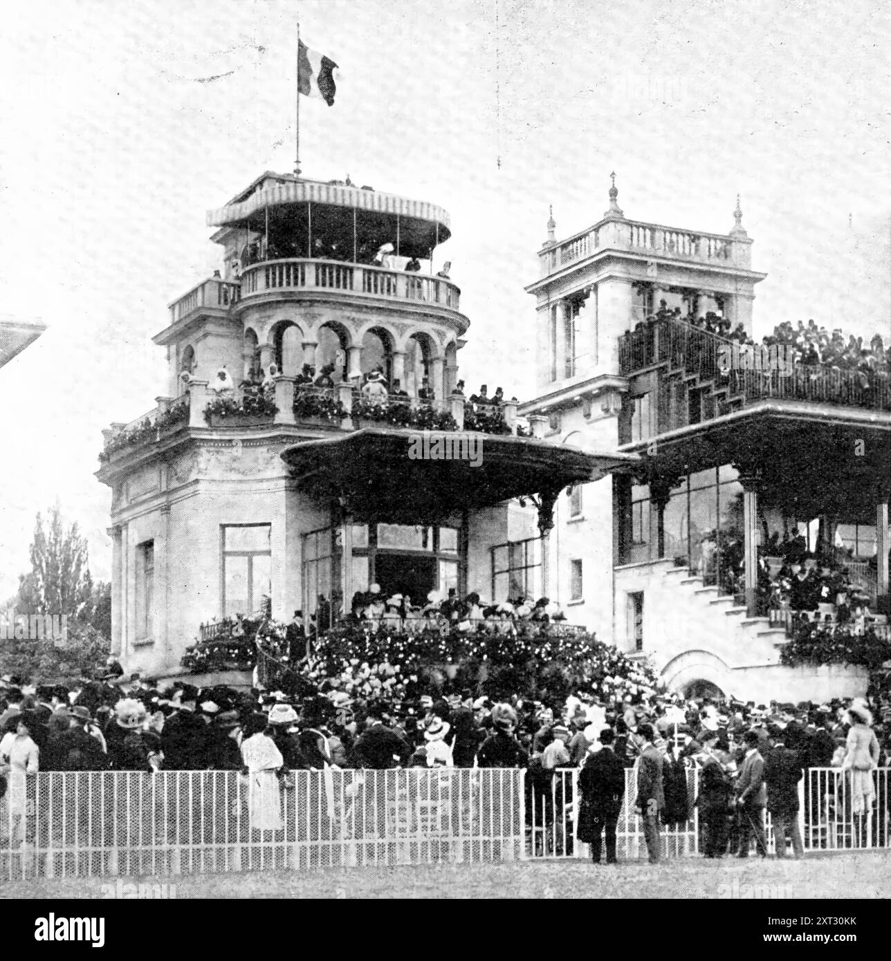 The French Derby: Der große Stand in Longchamp am Tag des Grand Prix 1909. "In der französischen Rennwelt nimmt der Grand Prix de Paris einen Platz im öffentlichen Interesse ein, analog zu dem, was der Derby in diesem Land hält. Unser Bild zeigt die animierte Szene auf dem Grand Stand in Longchamp am vergangenen Sonntag, anlässlich des Grand Prix, der von Baron Maurice de Rothschilds Verdun' [geritten von Barat] gewonnen wurde. Aus Illustrated London News, 1909. Stockfoto