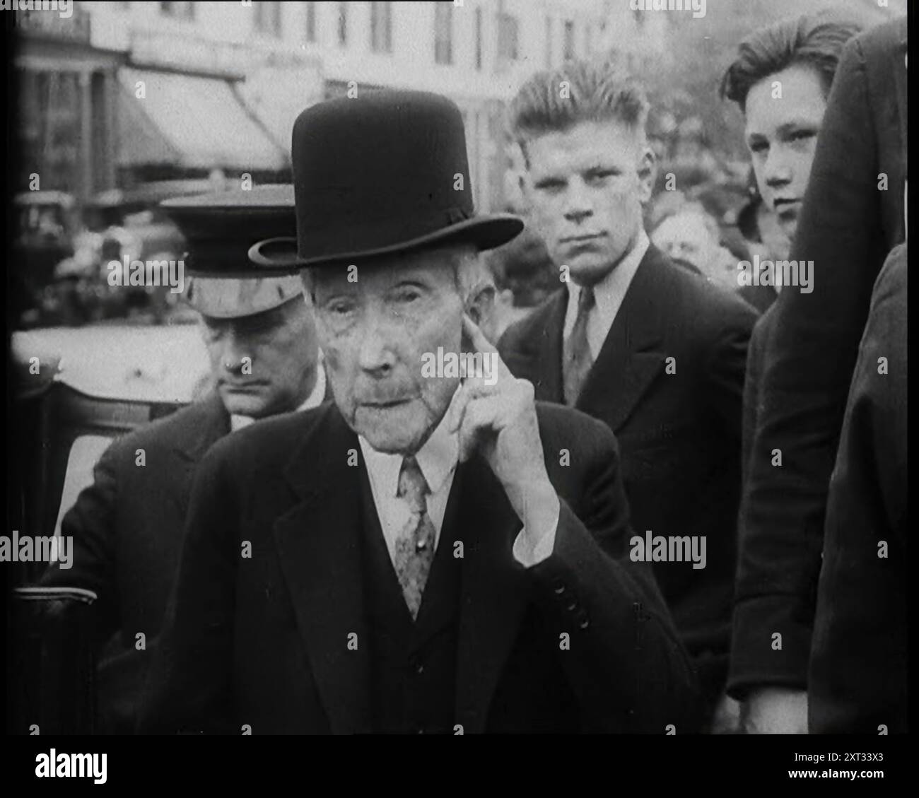 John D. Rockefeller steht mit anderen Leuten neben einem Auto, 1933. Aus „Time to Remember – The Time of the Monster“, 1933 (Reel 1); Dokumentarfilm über die Ereignisse von 1933, Rise of Roosevelt and Hitler. Stockfoto