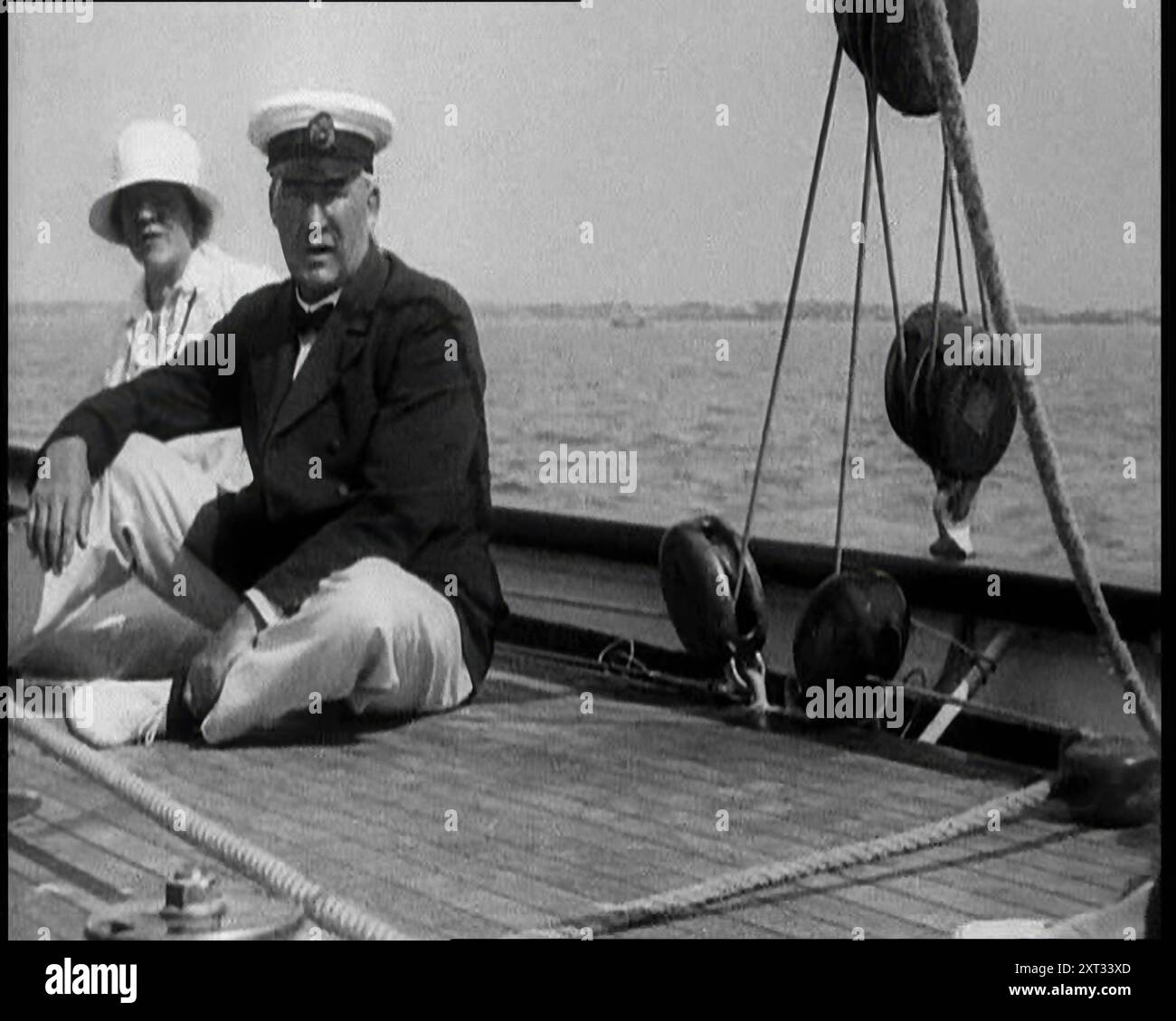 Ein Mann und eine Frau sitzen auf dem Deck einer Yacht bei Cowes, 1933. Segeln vor der Isle of Wight. Aus „Time to Remember – The Time of the Monster“, 1933 (Reel 4); ein Dokumentarfilm über die Ereignisse von 1933, Rise of Roosevelt und Hitler. Stockfoto