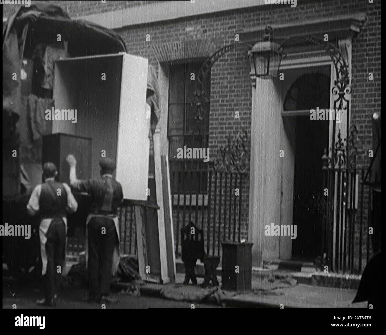 Zwei männliche Zivilisten laden Möbel in einen Van außerhalb der Downing Street 10, 1924. Aus "Time to Remember - A Trip to Europe", 1924 (Rolle 2); ein Blick auf das politische und soziale Leben in Europa und darüber hinaus im Jahr 1924. Stockfoto