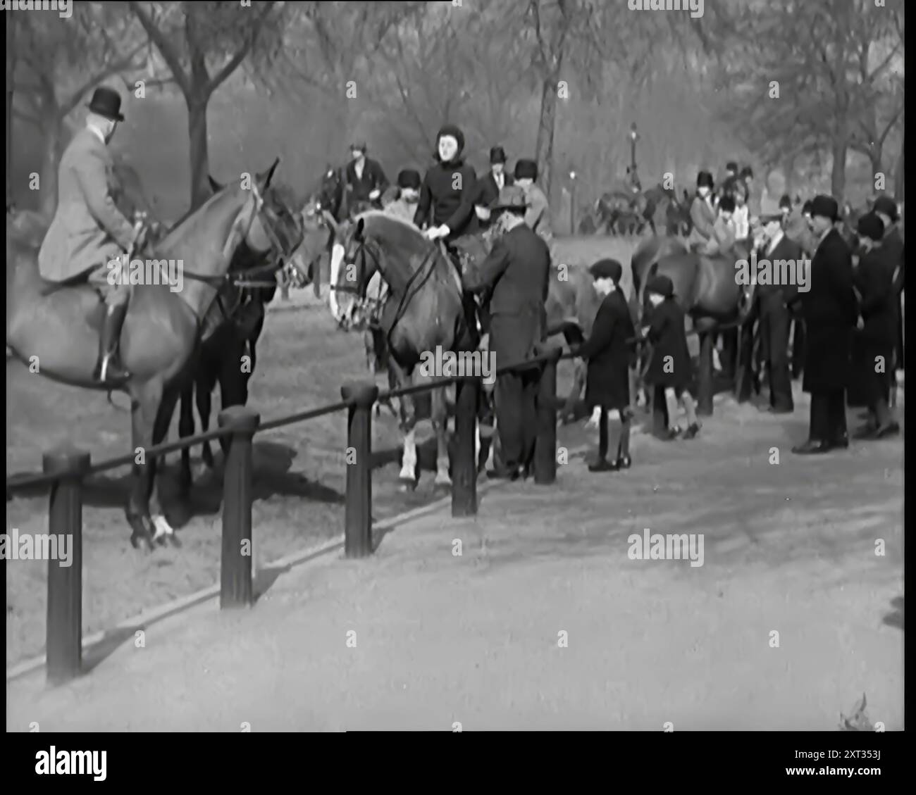 Pferde reiten in Rotten Row im Hyde Park, London, 1931. "Der erste der dreißiger Jahre. Eine Zeit des Optimismus - vielleicht vage und woll, aber immer noch Optimismus. Ein neuer Look für diejenigen, die im Park rauf und runter gehen. Kleide dich weniger formell, aber immer noch das stabile alte Großbritannien. Kein kalter Krieg, keine Wasserstoffbomben, und obwohl die Welt wohl und wirklich in der wirtschaftlichen Flaute ist, war es immer noch ein wunderbarer Ort. Besonders, als du jung warst. Aus „Time to Remember – A New Era“, 1931 (Reel 1); Dokumentarfilm über die Welt in den frühen 1930er Jahren Stockfoto