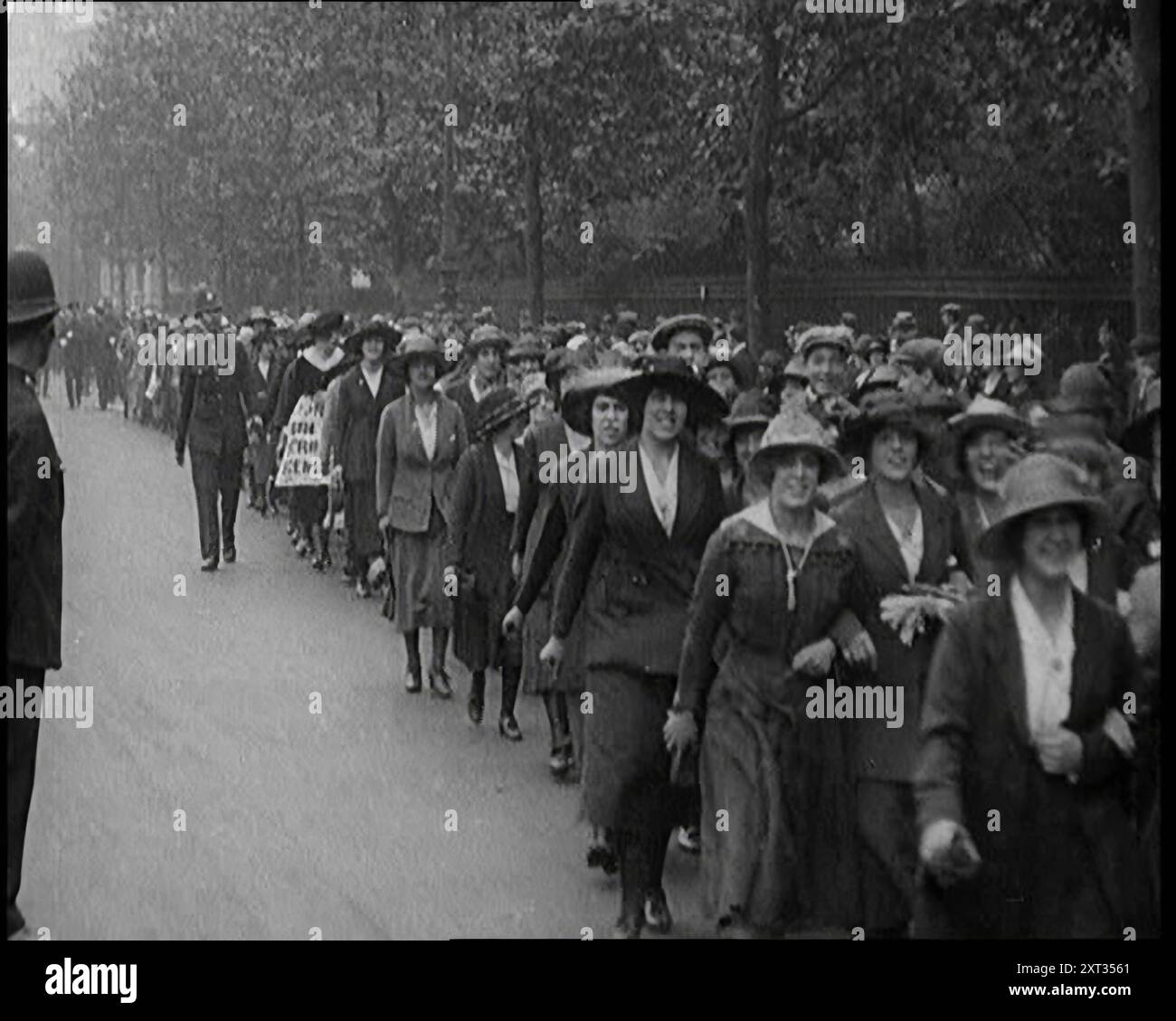 Markante Tea Shop Ladies, die die Straße hinuntermarschieren, flankiert von der Polizei, 1920. Frauen gehen während des Bergarbeiterstreiks raus. '...being in der Zeit der weiblichen Emanzipation waren auch Damen manchmal in Waffen. Teeshop-Kellnerinnen protestierten gegen die unfaire Behandlung einer ihrer Leute. Es gab einen Mangel an Tassen Tee und Kohle. Aus "Time to Remember - the Plunge into Peace", 1920 (Reel 2); Ereignisse von 1920 - Hochzeiten, Frauenrechte, industrielle Unruhen und Probleme in Irland Stockfoto