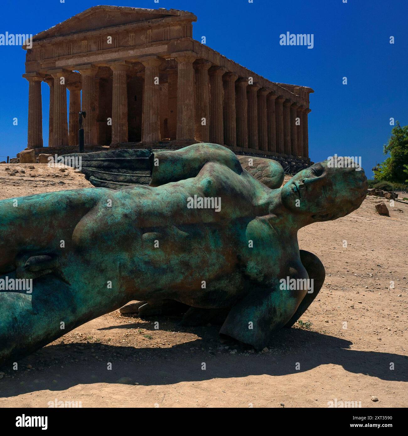 Gefallener Icarus oder Icaro Caduto, eine Bronzeskulptur des polnischen Bildhauers Igor Mitoraj (1944–2014), und der Tempel der Concordia oder Tempio della Concordia, ein altgriechischer Tempel, der in den 400er Jahren v. Chr. in Agrigento, Sizilien, Italien erbaut wurde. Stockfoto