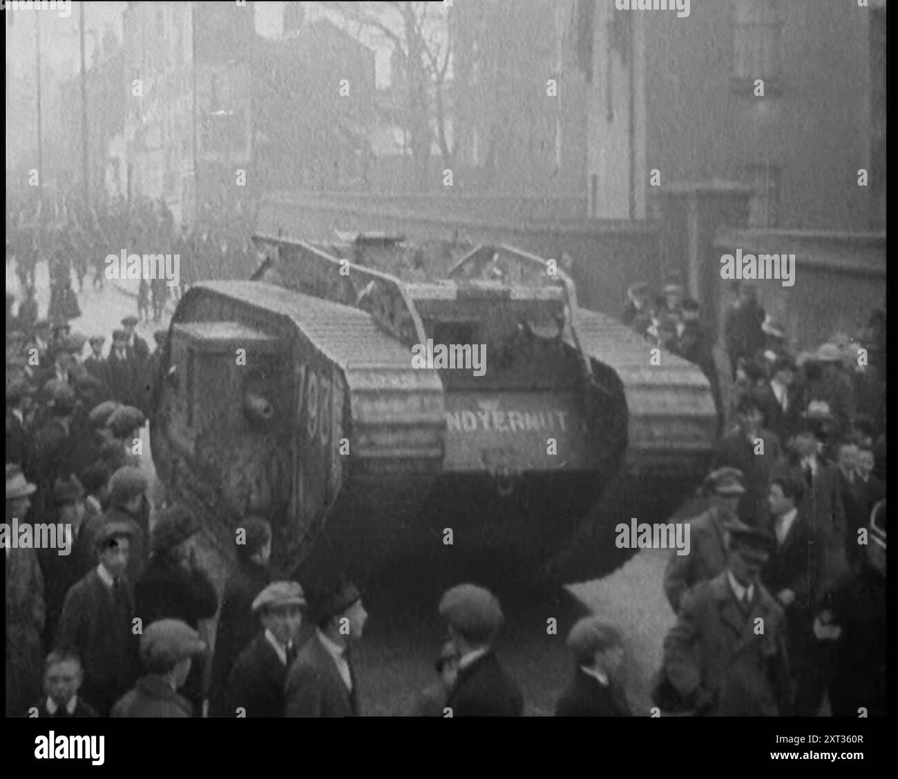 Ein Panzer, der die Massen von Demonstranten in Dublin zerstört, 1920. 'Vor Dublins Mountjoy Gefängnis, in dem so viele ihrer Freunde gefangen waren, zeigten wütende Menschenmassen den Geist ihrer Stadt durch Demonstrationen, dass nur schwere Rüstungen zerbrechen könnten. Aber könnte dieser Geist wirklich aufgelöst werden? Wer auch immer verhaftet wurde, es gab immer jemanden, der die Flagge der irischen Unabhängigkeit hochhielt. Immer jemand, der das Grün trägt. Aus "Time to Remember - the Plunge into Peace", 1920 (Reel 4); Ereignisse von 1920 - Hochzeiten, Frauenrechte, industrielle Unruhen und Probleme in Irland Stockfoto