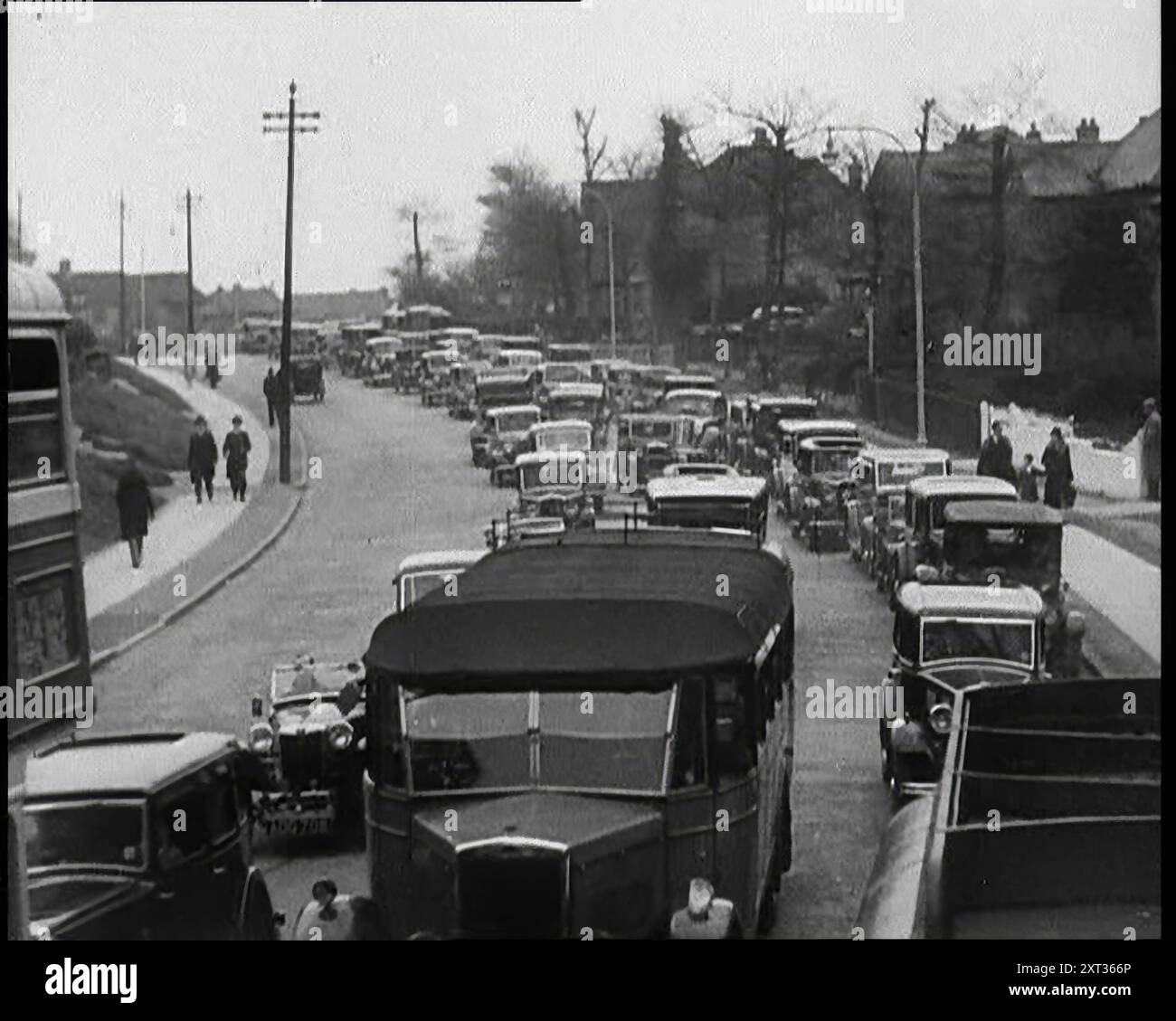 Autos, die eine Straße zur Kamera hinunterfahren, 1930er Jahre Aus "Time to Remember - Some People in the Thirties", 1930er Jahre (Rolle 1); Dokumentarfilm über die 1930er Jahre, der sich auf berühmte Charaktere dieser Zeit konzentriert. Stockfoto