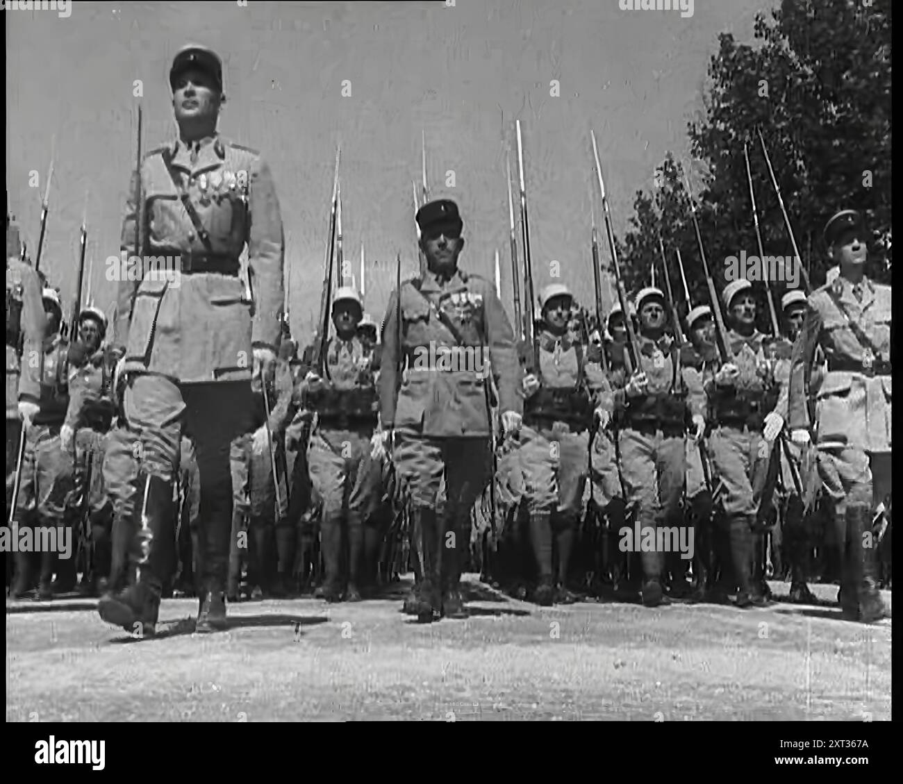 Linien männlicher Soldaten der französischen ausländischen Legion, die während der Bastille Day Military Parade 1939 auf die Kamera marschierten. Aus „Time to Remember – The Reluctant Warriors“, 1939 (Reel 1); Dokumentarfilm über Ereignisse von 1939 – Vorbereitungen für den Krieg und dann Feindseligkeiten brechen aus. Stockfoto