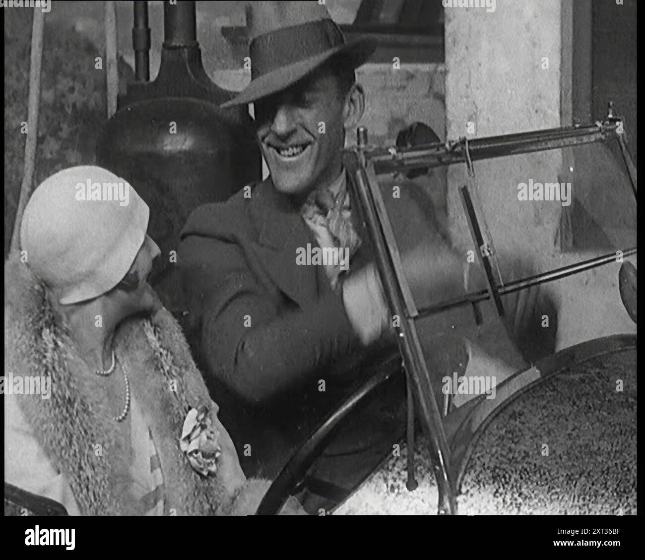Jack Hulbert kletterte in ein Auto und steckte seine Finger in die Windschutzscheibe, 1920er Jahre Britische Theatervorstellung. „Ein widerstrebendes Babyauto, so viel Wut... und versucht, es und seine Freundin gleichzeitig zu bewältigen“. Aus „Time to Remember – On Stage in the Twenties“, 1927 (Reel 3); ein Blick hinter die Kulissen des Theaters in den 1920er Jahren Stockfoto