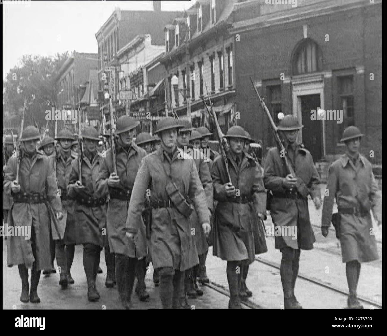 Truppen der US-Armee mit Waffen marschieren, 1932. „Angesichts solcher Sturheit [ziviler Unruhen] ergreifen die Machthaber manchmal stärkere Maßnahmen, als in einer Demokratie gesund sind, aber die Zeiten sind so, dass auch die Machthaber ängstlich werden und Revolution in jeder Bewegung sehen, die sie für verfassungswidrig halten. Truppen und Waffen. Nur eine Kraftentfaltung, so fühlen sie, kann den Eifer der Hitzköpfe kühlen, die immer die Wurzel dieser industriellen Störungen sind. Aber wenn es um die Prüfung geht, dann haben sie sich oft als irrtümlich erwiesen. Aus „Time to Remember – Around the Corner“, 1932 (Rolle 2); Tagebuch von Eve Stockfoto