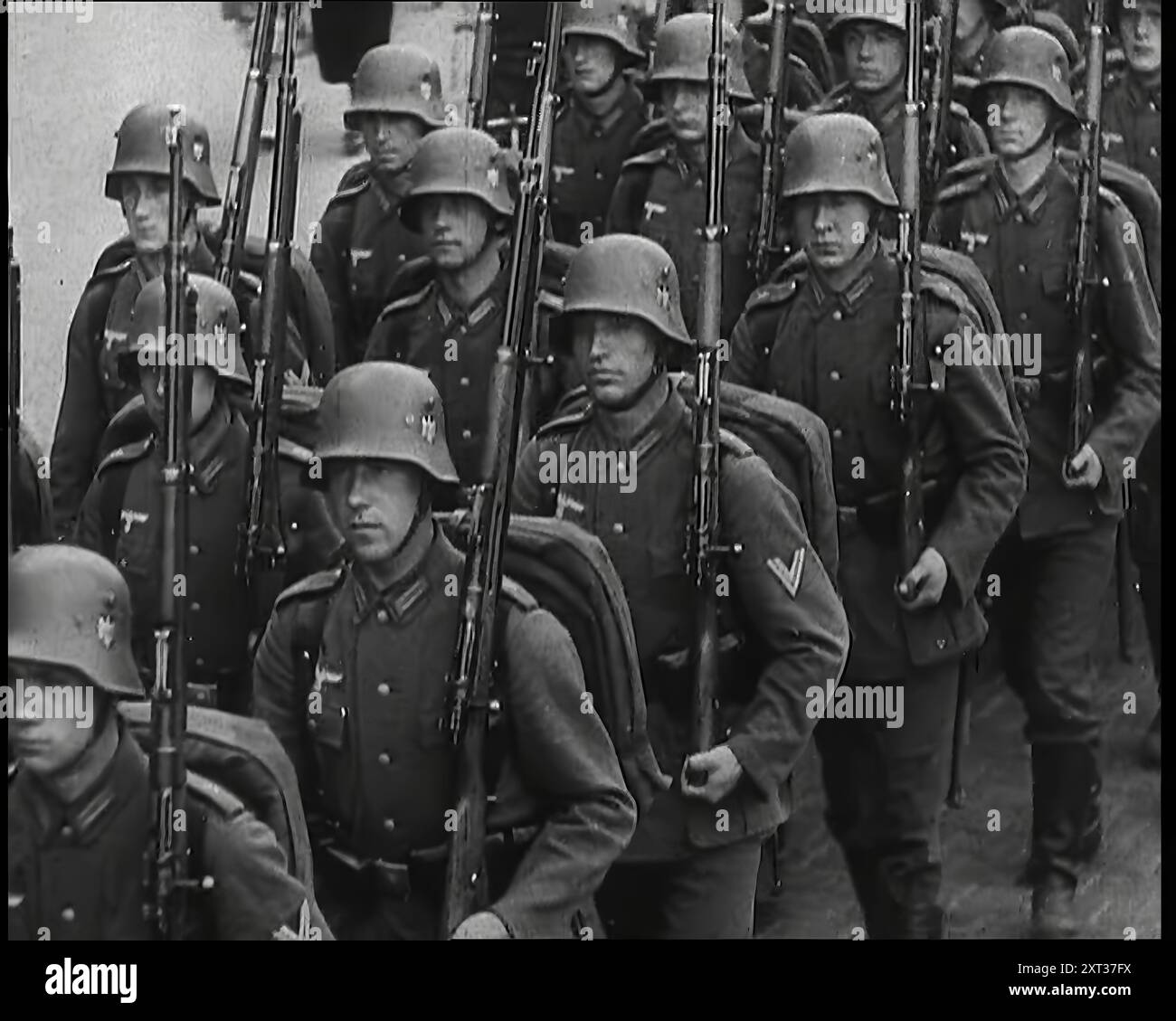 Ein Regiment männlicher deutscher Soldaten marschierte entlang einer deutschen Straße, 1939. Aus „Time to Remember – The Reluctant Warriors“, 1939 (Reel 4); Dokumentarfilm über Ereignisse von 1939 – Vorbereitungen für den Krieg und dann Feindseligkeiten brechen aus. Stockfoto