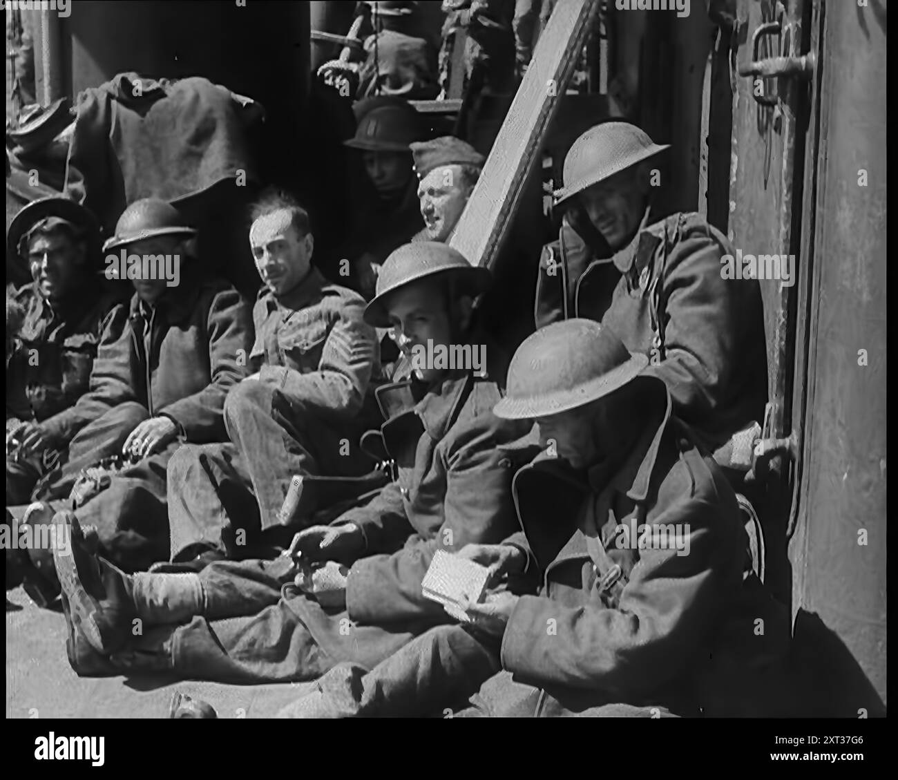 Britische Soldaten sitzen an Bord eines Schiffes, das sie nach der Evakuierung von Dunkirk 1940 über den Ärmelkanal brachte. Zweiter Weltkrieg. Männer, die gekämpft und marschiert haben, marschiert und gekämpft haben, brauchen alles, was ihnen gegeben werden kann. Aber die Luftwaffe ist nicht leicht ihrer Beute zu entziehen. Während des Tageslichts sind Angriffe oft unaufhörlich... es gibt keine Panik, nur die Schnelligkeit der Notwendigkeit und gewagte Improvisation. Die Royal Navy stellt eine Armee bereit, die nach Großbritannien tritt, und diese Armee ist keine Armee, die wegen eines Schiffes verloren gehen sollte." Aus „Time to Remember – Run Rabbit Run&quot Stockfoto