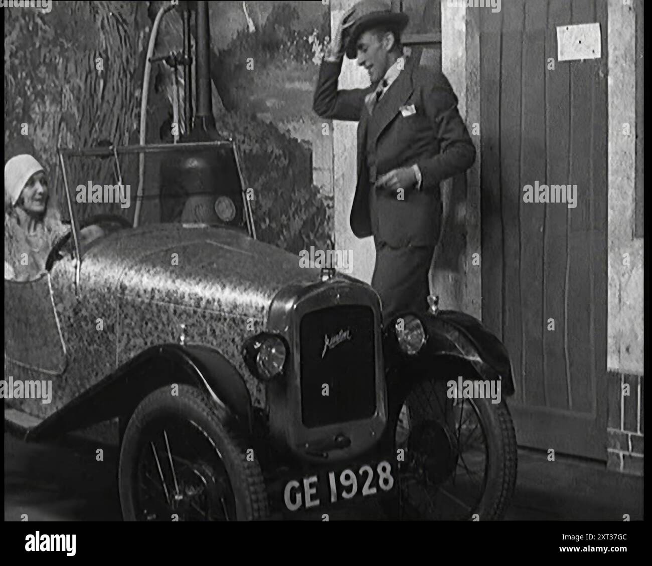 Jack Hulbert klettert in ein Auto, 1920er Britische Theatervorstellung. „Ein widerstrebendes Babyauto, so viel Wut... und versucht, es und seine Freundin gleichzeitig zu bewältigen“. Aus „Time to Remember – On Stage in the Twenties“, 1927 (Reel 3); ein Blick hinter die Kulissen des Theaters in den 1920er Jahren Stockfoto