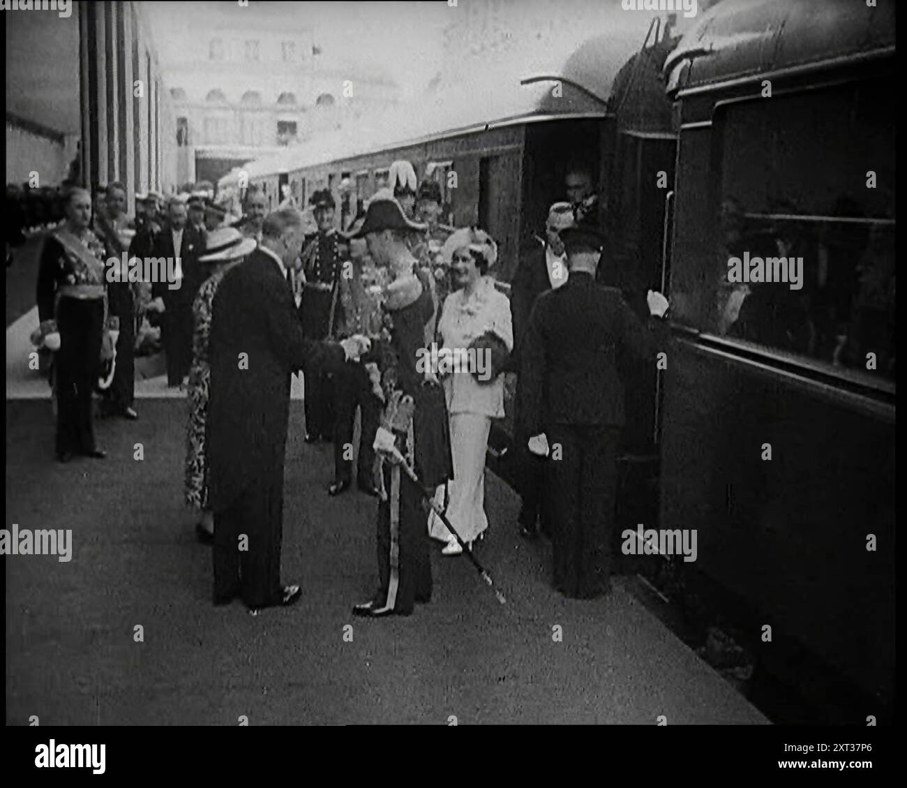 König Georg VI. Und Königin Elisabeth von Großbritannien werden in Paris am Bahnhof Bois de Boulogne von dem französischen Präsidenten Albert Le Brun und seiner Frau Marguerite Le Brun und Beamten während des königlichen Staatsbesuchs in Frankreich 1938 begrüßt. Aus „Time to Remember – Wind Up Week“, 1938 (Reel 2); Dokumentarfilm über 1938 – die Menschen werden sich der wachsenden Bedrohung des Krieges bewusst. Stockfoto