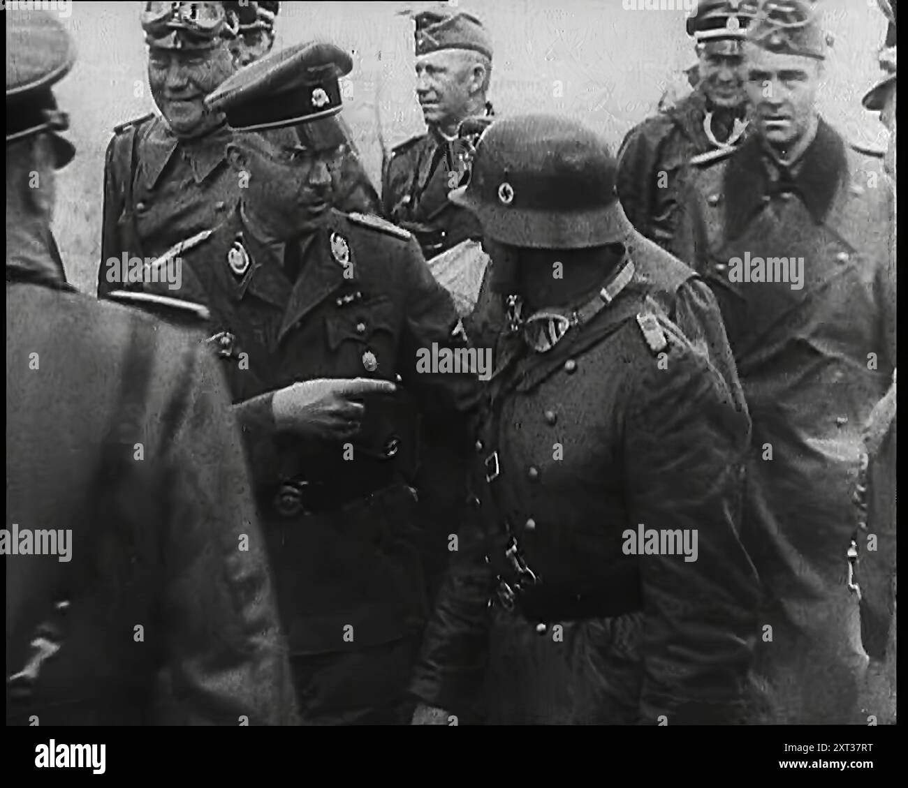 Heinrich Himmler steht neben und zeigt auf einen deutschen Heereskommandeur, dahinter stehen weitere Militäroffiziere, 1939. Aus „Time to Remember – The Reluctant Warriors“, 1939 (Reel 3); Dokumentarfilm über Ereignisse von 1939 – Vorbereitungen für den Krieg und dann Feindseligkeiten brechen aus. Stockfoto