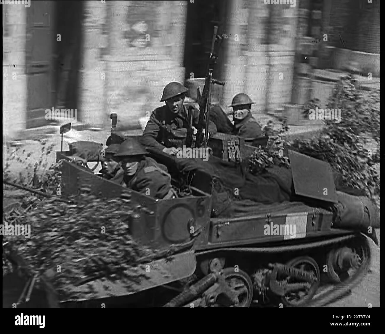 Britische Expeditionstruppe zieht sich mit Fahrzeugen durch Belgische Stadt zurück, 1940. Zweiter Weltkrieg. 'Aus dem Norden Belgiens zieht sich die britische Expeditionstruppe zurück, die fast so schnell zurückspringt wie nach dem Vorwärtsrennen. Aber obwohl sie überholt ist, ist sie eine Streitmacht, die immer noch eine Kampfeinheit ist, obwohl es problematisch ist, wie lange sie so bleiben kann." Aus „Time to Remember – Run Rabbit Run“, 1940 (Reel 3); Dokumentarfilm über Ereignisse in den frühen Monaten des Jahres 1940. Stockfoto